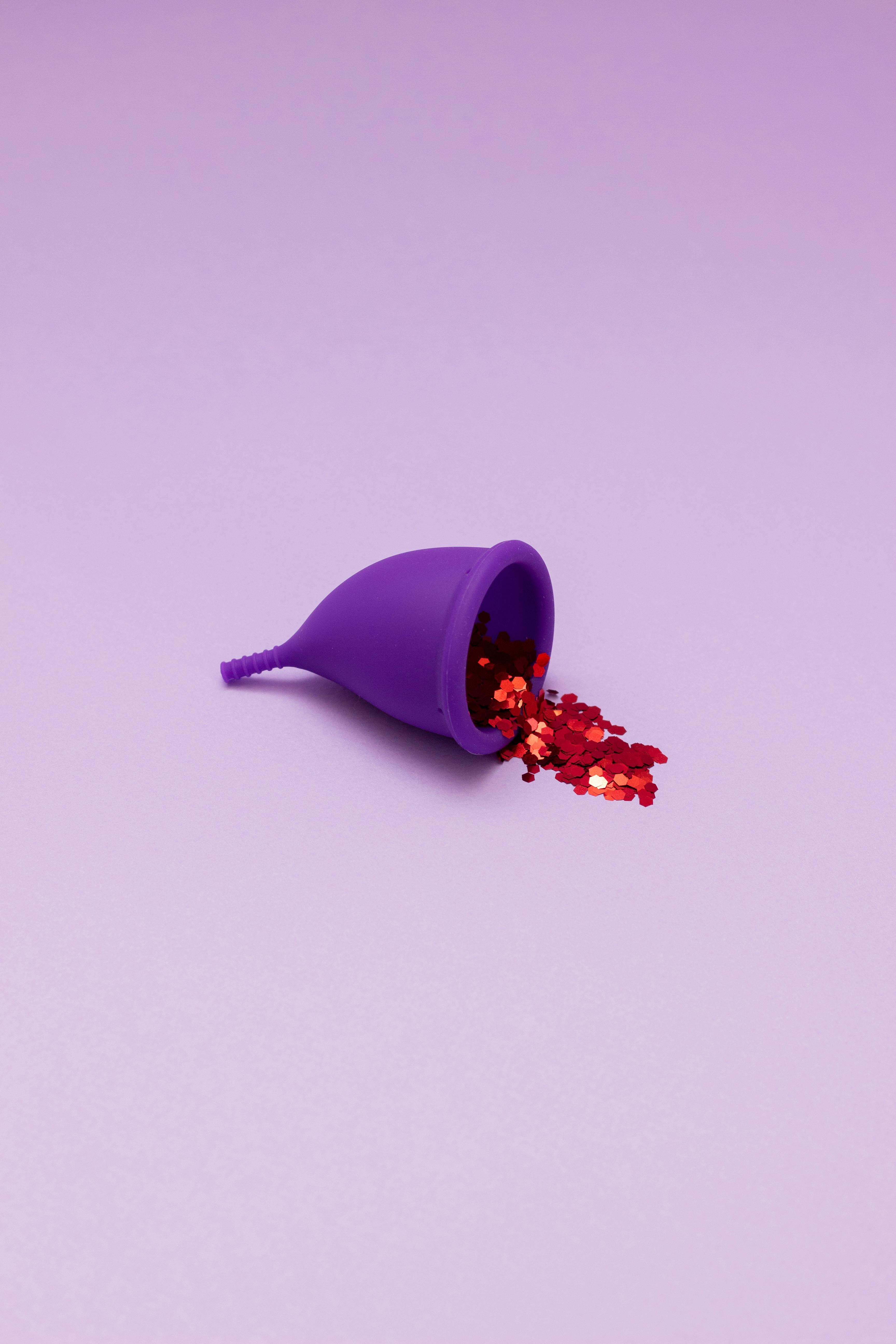 Woman troubleshooting a leaking menstrual cup by checking positioning, size and seal for a leak-free period